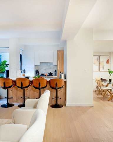 Open-plan apartment with kitchen, dining area, and living room featuring wood flooring and modern furnishings